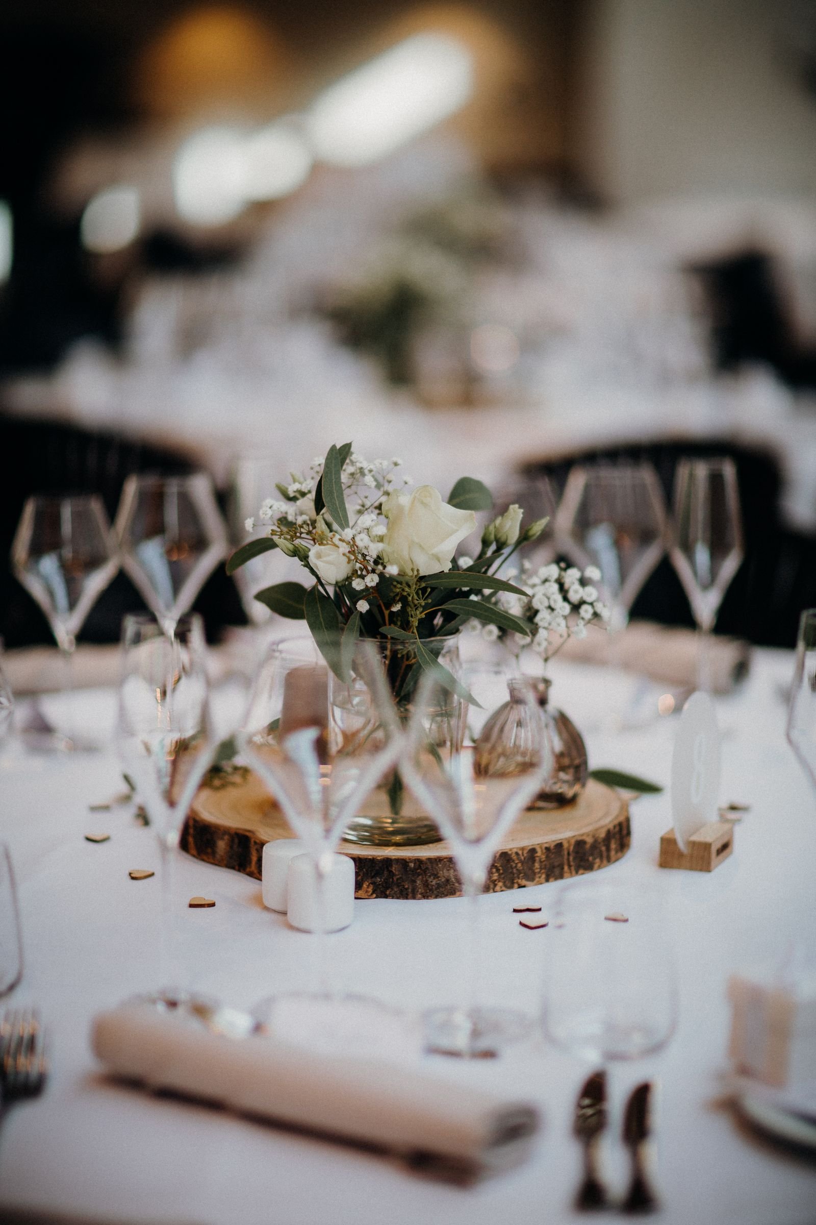 White floral centerpiece and glassware at an intimate wedding table